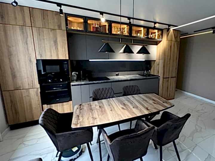 Просторная кухня в стиле лофт с серыми фасадами с деревом - фото - 1