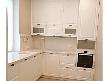 Неоклассическая кухня с фрезерованными белыми фасадами и просторной рабочей зоной под окном - фото - 2