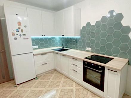 Белая угловая кухня в стиле неоклассика со столешницей под светлое дерево - фото - 1