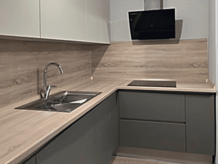 Угловая кухня с навесными шкафами под потолок, деревянным фартуком и столешницей - фото - 1