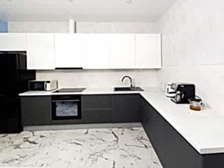 Угловая современная кухня в бело-сером цвете с просторной рабочей зоной - фото - 1