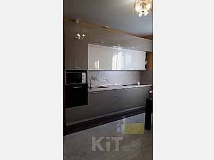 Современная серая кухня с двухъярусными навесными шкафами разной глубины - фото - 1