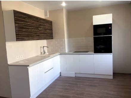 Белый кухонный гарнитур в современном стиле, встроенный в помещение нестандартной формы - фото - 1