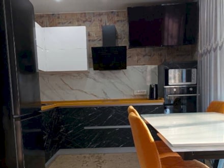 Угловая черно-белая кухня с акцентной горчичной столешницей - фото - 4