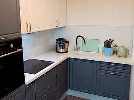 Угловая неоклассическая кухня с серыми рамочными фасадами - фото - 1