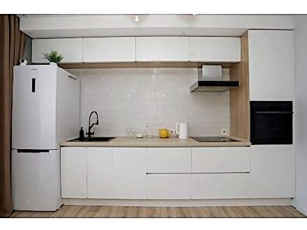 Прямая кухня с белыми фасадами и древесным декором - фото - 7