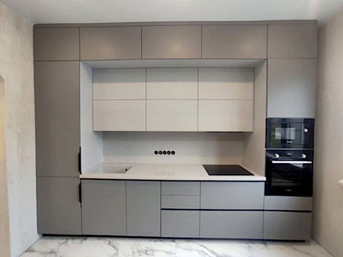 Встроенная нюдово-серая кухня с пеналами по бокам - фото - 1