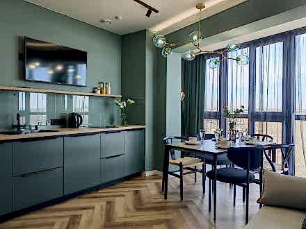 Изумрудная кухня в сочетании с теплым деревом - фото - 2